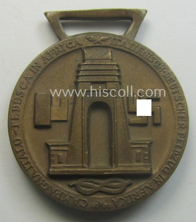 Golden-bronze-coloured (and 'Buntmetall'-based!) example of a: 'Deutsch-Italienische Feldzugsmedaille' (or: German-Italian campaign-medal) that came together with its (full length- and 'virtually mint- ie. unissued') piece of original ribbon