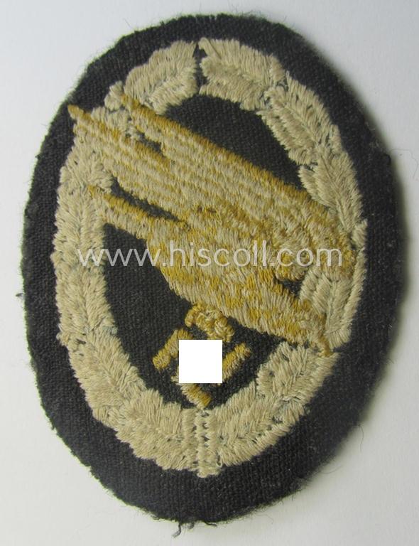 WH (Luftwaffe) 'Fallschirmschützen-Abzeichen in Stoff' (or: cloth-based paratroopers'-jump-badge) being a nicely machine-embroidered specimen that comes in a just moderately used- ie. carefully tunic-removed, condition