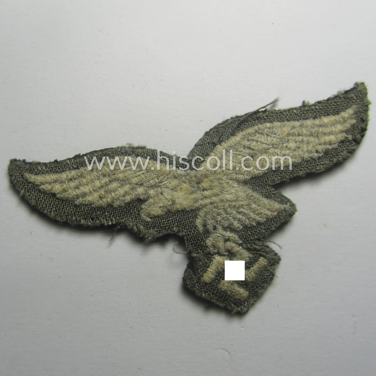 Minimally used, WH (Luftwaffe) cap-eagle (being a 'standard-issue'-pattern example that is executed onto a black-coloured background and that was as such intended for usage on the black-coloured work- ie. 'HG'-related side-caps ie. 'Schiffchen')