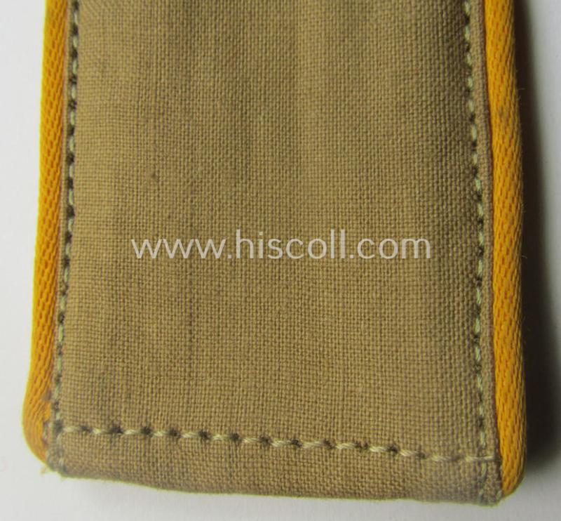 Single, WH (Luftwaffe) tropical-issued, EM-type-shoulderstrap as executed in beige-coloured linnen (as was specifically intended for usage on the tropical-shirts ie. tunics) as was intended for a: 'Soldat der Flieger- o. Fallschirmjäger-Trpn.'