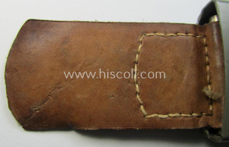 Superb, WH (Heeres) field-grey-coloured- and/or steel-based belt-buckle being (an unusally seen!) non-maker-marked- nor dated example that comes mounted onto its (light-brown-coloured) leather-based tab and that comes in a wonderful condition