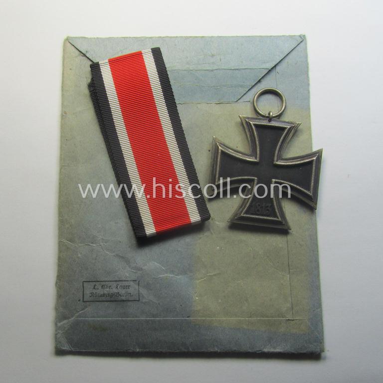 Matching 'EK II. Klasse'-set comprising of a non-maker-marked specimen that comes with its ribbon (ie. 'Bandabschnitt') and 'Zellstoff'-based pouch as was produced by the company: 'L.Chr. Lauer' (ie. 'Hersteller 14')