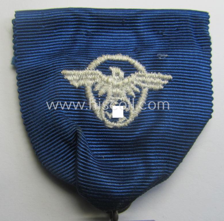 Silver-class 'Pol.-Dienstauszeichnung 2. Stufe' (or: police loyal-service medal second-class) that comes mounted onto its (typically broader-shaped) ribbon (ie. 'Bandabschnitt')