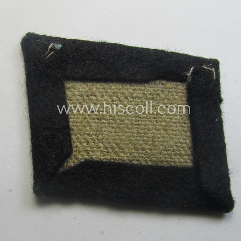 Waffen-SS EM-pattern rank-collar-rank-tab ('Kragenspiegel') being a 'standard-issue'-pattern example as executed in black-coloured wool as was intended for usage by an: 'SS-Mann'