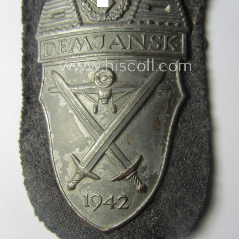WH (Luftwaffe) 'Demjansk'-campaign-shield as executed in typical magnetic metal (ie. so-called: 'Eisenblech') and that comes in an overall nice- (ie. most certainly worn but nevertheless ie. fully untouched!), condition