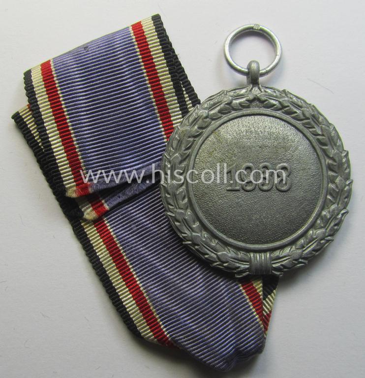 'Luftschutz-Ehrenzeichen 2. Stufe' being a maker- (ie. '10'-) marked example, as executed in (heavy) zinc-based metal (ie. 'Feinzink') and that came together with its period ribbon (ie. 'Bandabschnitt')