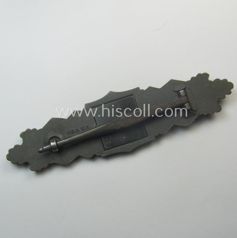 'Nahkampfspange in Bronze' (or: bronze-class close-combat clasp ie. CCC) being a neatly maker-marked- and/or minimally converse-shaped specimen as was produced by the: 'JFS'- (ie. 'Joseph Feix u. Söhne'-) company