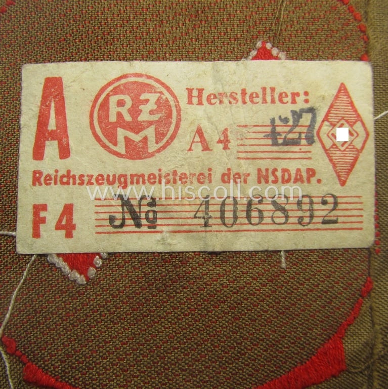 Moderately used, DJ (ie. 'Deutsches Jungvolk') arm-badge as was specifically intended for usage by a member who served within the: 'Oberbann 1' (being a tunic-removed example that still shows its 'RzM'-etiket)
