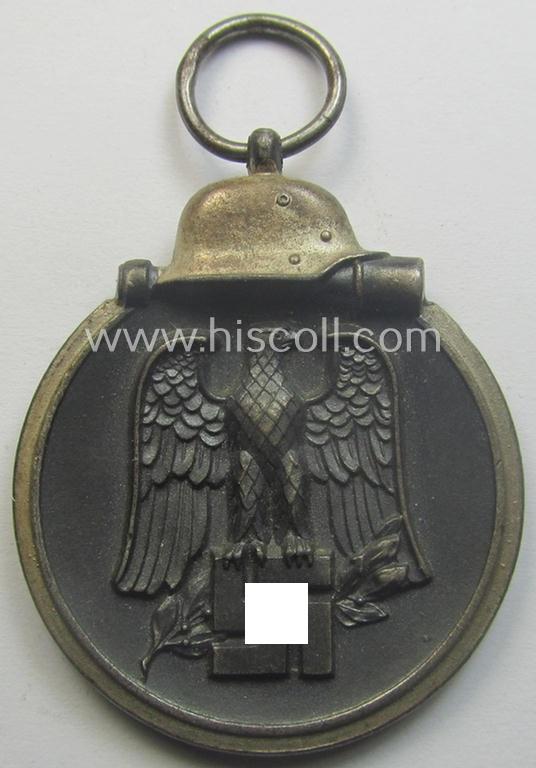 Medal-set: 'Winterschlacht im Osten 1941-42' being a maker- (ie. '93'-) marked- (and/or 'Feinzink'-based) specimen by the maker: 'Richard Simm & Söhne' and that comes together with its (minimally confectioned) ribbon (ie. 'Bandabschnitt')