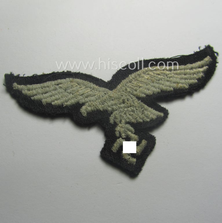 Minimally used, WH (Luftwaffe) cap-eagle (being a 'standard-issue'-pattern example that is executed onto a black-coloured background and that was as such intended for usage on the black-coloured work- ie. 'HG'-related side-caps ie. 'Schiffchen')