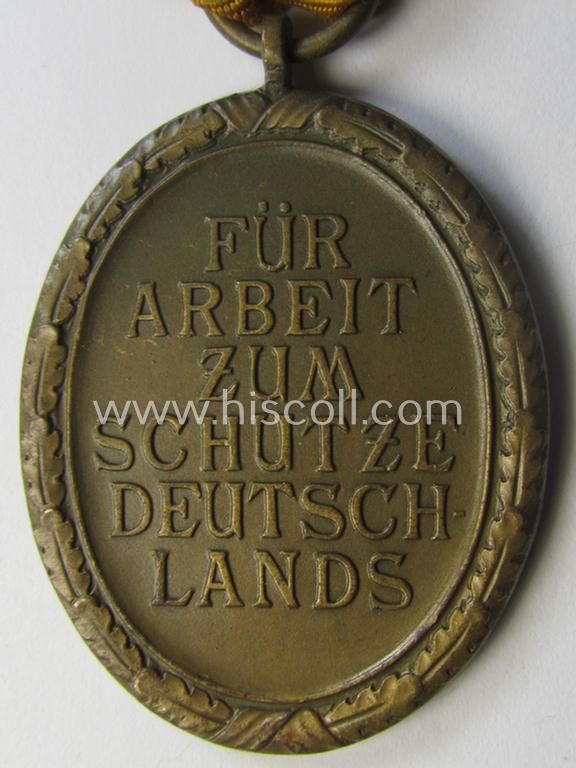Medal-set: 'Deutsches Schutzwall Ehrenzeichen' (aka: 'Westwall'-medal) being a non-maker-marked- and/or: 'Buntmetall'-based specimen that comes mounted onto its period- (and neatly folded ie. pre-confectioned) ribbon (ie. 'Bandabschnitt')