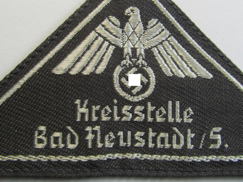 Attractive, German Red Cross (ie. 'Deutsches Rotes Kreuz' or 'DRK') greyish-coloured- and/or (typically) triangular-shaped arm-eagle entitled: 'Kreisstelle Bad Heustadt / S.' as was executed in the neat 'BeVo'-weave pattern