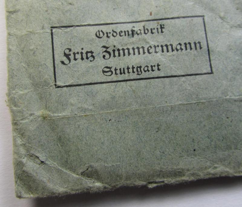 Neat - and matching! - 'EK II. Klasse'-set comprising of a non-maker-marked specimen that comes with its original ribbon (ie. 'Bandabschnitt') and 'Zellstoff'-based pouch as  produced by the company: 'F. Zimmermann' (ie. 'Hersteller 6')