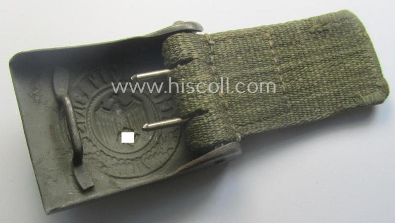 WH (Heeres) 'tropical-issued' belt-buckle being a clearly maker- (ie. 'HA'-) marked (and/or: '42'-dated) field-grey-coloured example that comes mounted onto its original, greenish-coloured- (and/or: 'webbing'-based-) tab