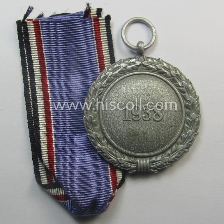 'Luftschutz-Ehrenzeichen 2. Stufe' being a maker- (ie. '10'-) marked example, as executed in (heavy) zinc-based metal (ie. 'Feinzink') and that came together with its period ribbon (ie. 'Bandabschnitt')