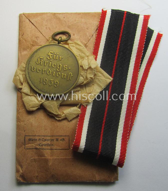 'Kriegsverdienstmedaille 1939'-set comprising of a non-maker-marked- (and/or: typical 'Buntmetall'-based!) specimen that came together with its period-ribbon and 'Zellstoff'-based pouch by the maker: 'Klein & Quenzer A.G. - Oberstein'