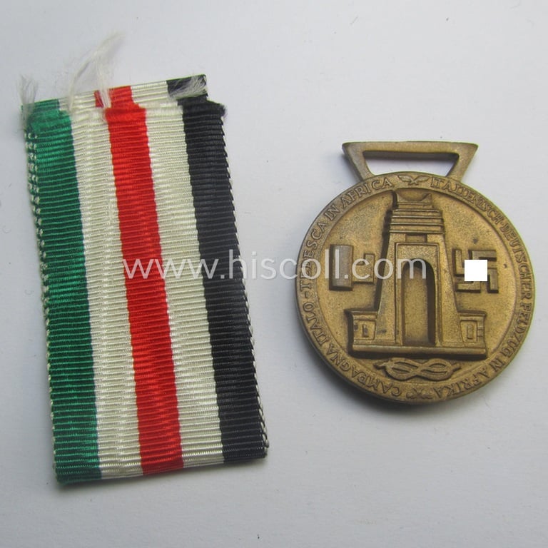 Golden-bronze-coloured (and 'Buntmetall'-based!) example of a: 'Deutsch-Italienische Feldzugsmedaille' (or: German-Italian campaign-medal) that came together with its (full length- and 'virtually mint- ie. unissued') piece of original ribbon