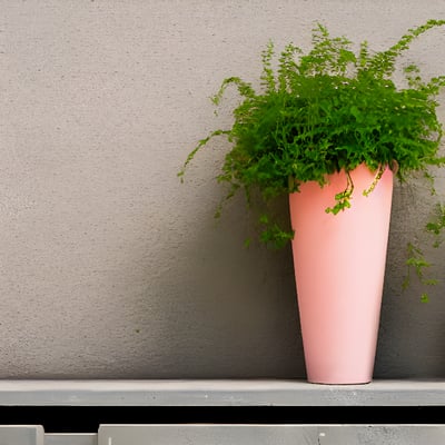 A plant in a pink vase on a ledge