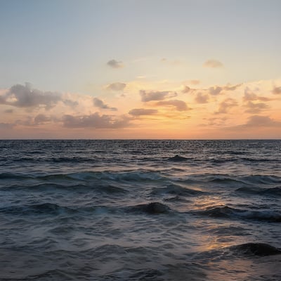 The sun is setting over the ocean with waves