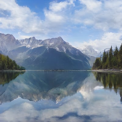 A mountain range is reflected in a still lake