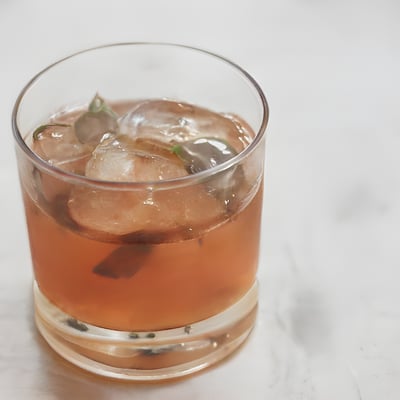 A glass filled with a drink sitting on top of a table