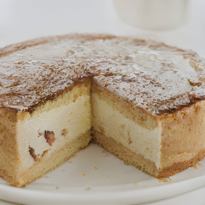 A white plate topped with a cake covered in powdered sugar