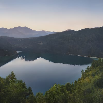 A large lake surrounded by trees and mountains