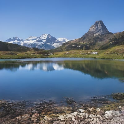 A lake surrounded by mountains and grass