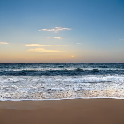 A sandy beach with waves coming in to shore