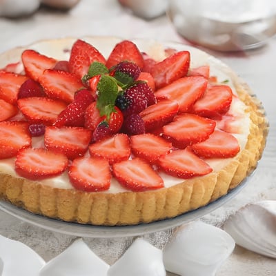 A pie with strawberries on top of it on a table