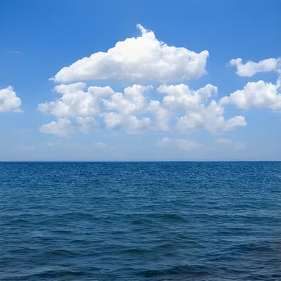 A large body of water under a cloudy blue sky