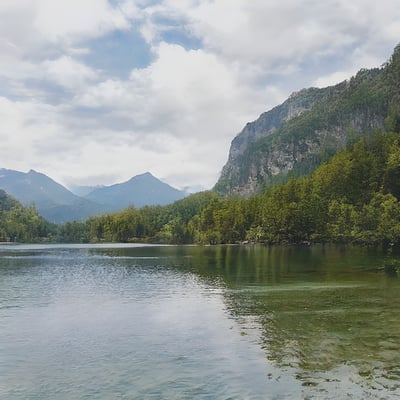 A body of water surrounded by mountains and trees