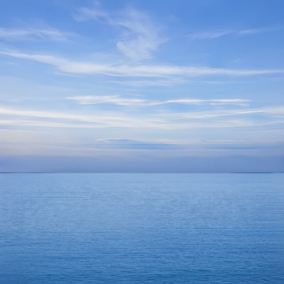 A large body of water sitting under a blue sky