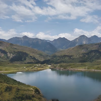 A lake surrounded by mountains under a cloudy sky