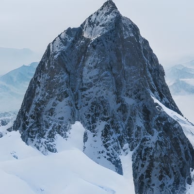 A person standing on top of a snow covered mountain