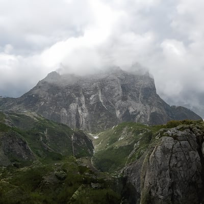 A mountain with a few clouds in the sky