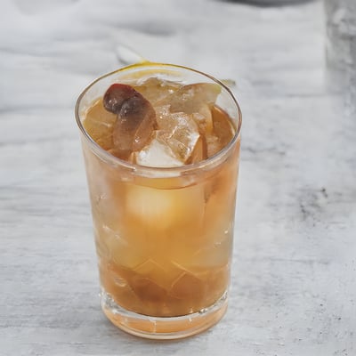 A glass filled with ice and a slice of fruit
