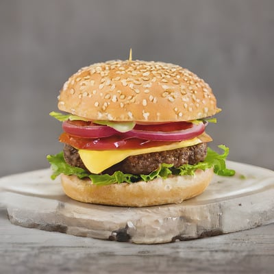 A cheeseburger with onions, lettuce and tomato