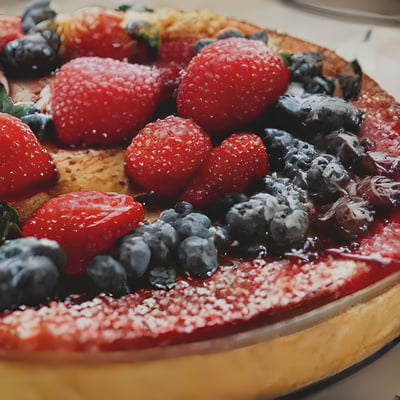 A cake with berries, blueberries, and raspberries on it