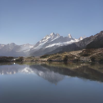 A mountain range is reflected in the still water of a lake