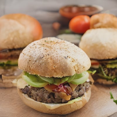 A close up of two hamburgers on a cutting board