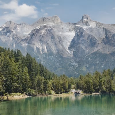 A mountain range with a lake surrounded by trees