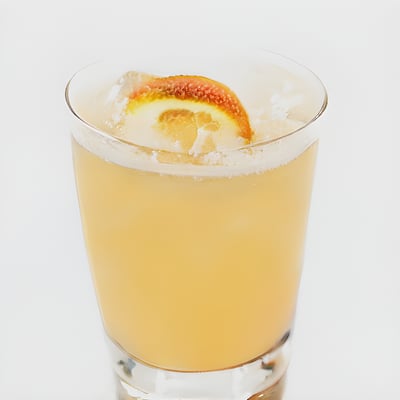 A glass of orange juice with a slice of orange on the rim