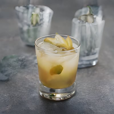 A glass filled with a drink sitting on top of a table