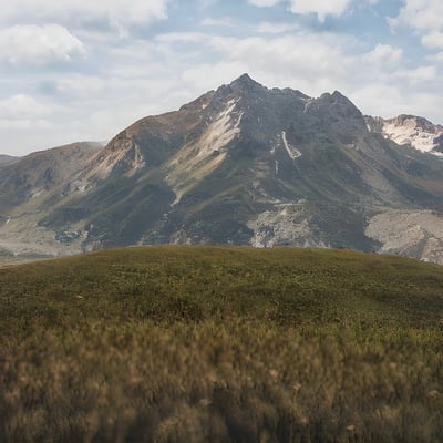 A mountain range with a few clouds in the sky