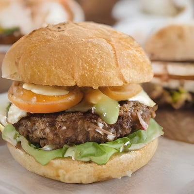 A hamburger sitting on top of a wooden cutting board