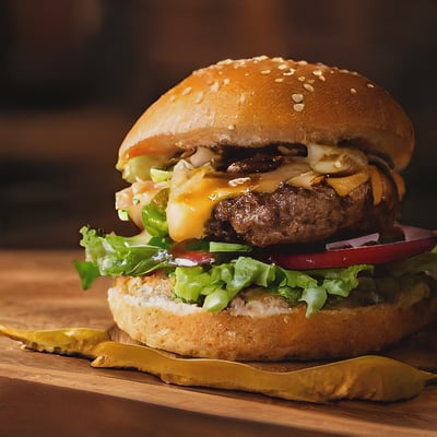 A hamburger sitting on top of a wooden cutting board