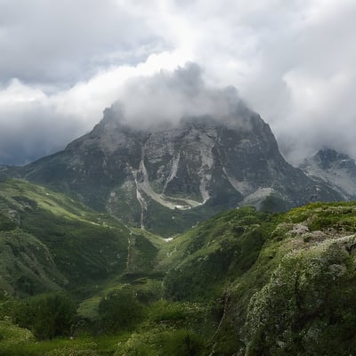 A view of a mountain range with clouds in the sky