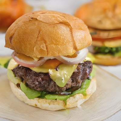 A hamburger on a plate with other hamburgers in the background