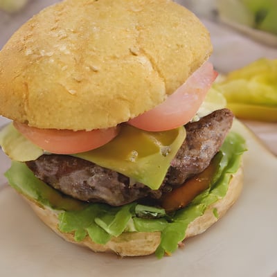 A hamburger with lettuce, tomato, and cheese